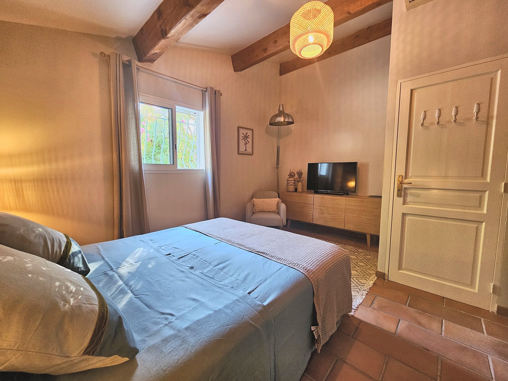 Chambre aux poutres apparentes, fenêtre sur le jardin